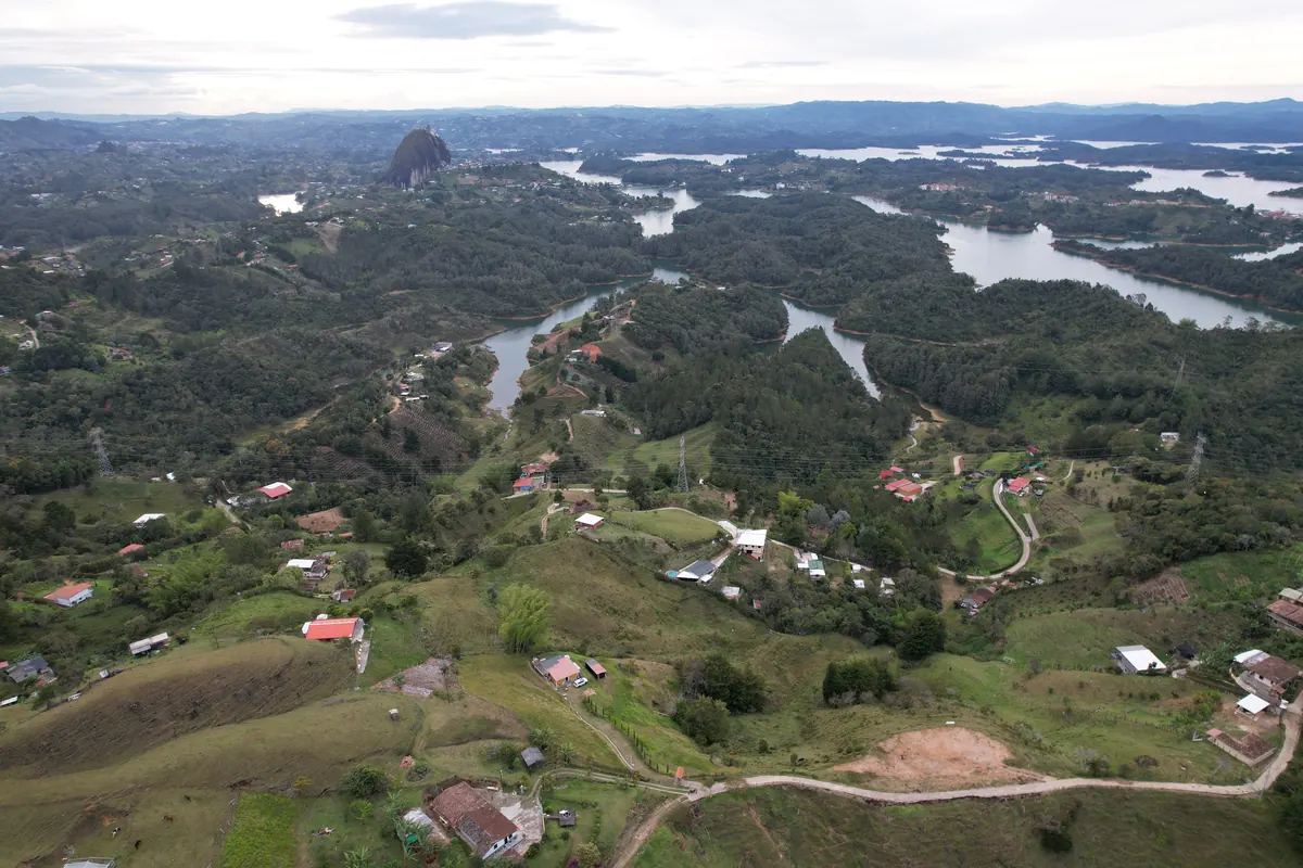 Panorámica aérea del sector Vista Hermosa en Guatapé con la Piedra del Peñol al fondo